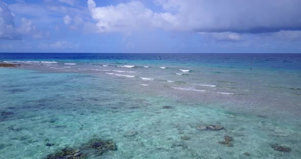Luxury flying clean view of a white sandy paradise beach and aqua blue ocean background in hi res 4K alt