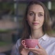 Brunette Caucasian Woman with Brown Eyes Looking Out Window Drinking Coffee in Slow Motion in Cafe - VideoHive Item for Sale