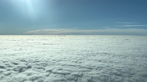 PILOT VIEW - From a jet plane cockpit, a dense flat blanket of cloud cover is seen below alt