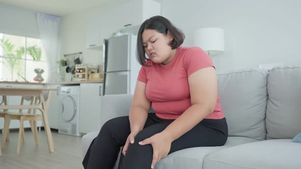 Asian attractive plus size big girl suffer from injured leg and walk to living room for massage body alt