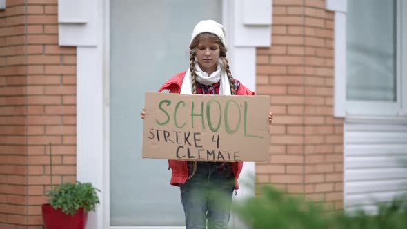 Confident Teenage Girl with School Strike for Climate Banner Standing Outdoors on Porch Looking at alt