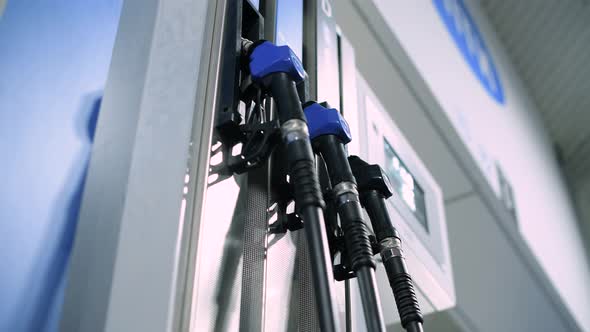 bottom view of refueling pistols, one of them is removed by a woman alt