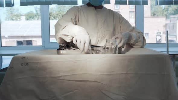 Nurse Putting Surgical Instruments on Table Preparing Tools for Operation alt