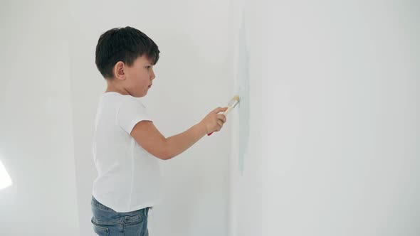 Caucasian Boy Paints White Wall Boy Makes House Repairs Boy Paints Blue Paint Side View