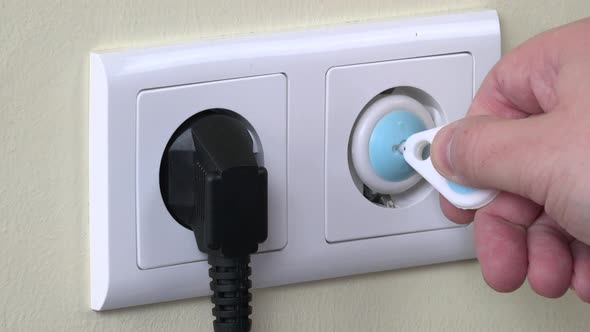 Hand Remove Safety Plug From Electricity Outlet And Insert Plug Wire