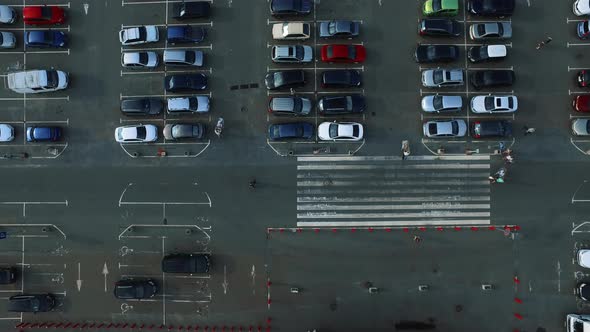 Drone Footage People Moving with Trolleys. Birds Eye View Car Leaving Parking alt