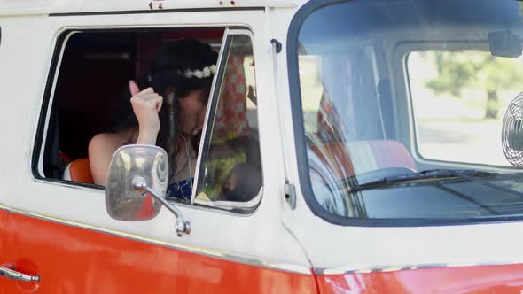 Woman enjoying music while sitting in camper van 4k alt