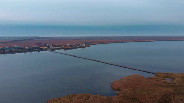 Empty estuary at sunrise with pedestrian bridge alt