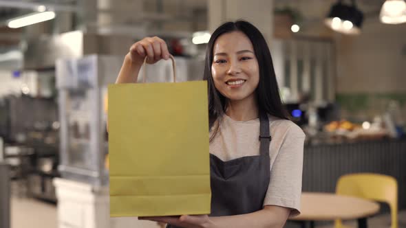 Pretty Asian Waitress Preparing Takeaway Meal at Cafe alt