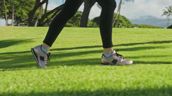 Close Up Athlete Woman Legs in Black Sport Pants Running By Green Lawn at Summer alt