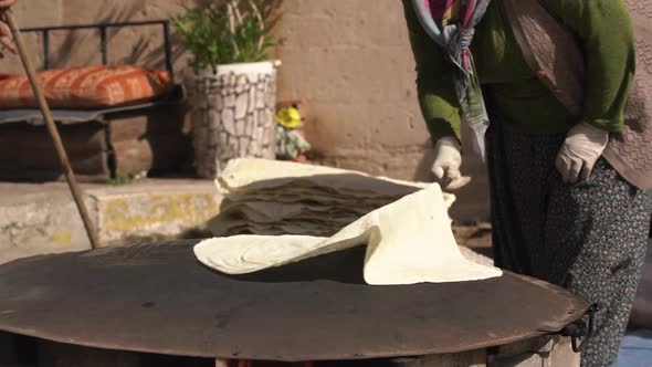 Lady in Long Polka Dot Dress Turns Dough Over Frying Surface alt