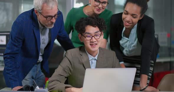 Colleagues Supporting and Congratulating Their Asian Coworker alt