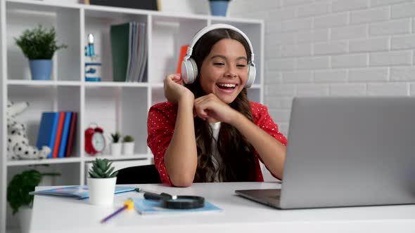 Happy Child in Headphones Laughing at Video Watching on Computer Technology