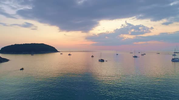 Colorful sunset above the sea surface with sail boats. Aerial view drone fly over Phuket sea alt