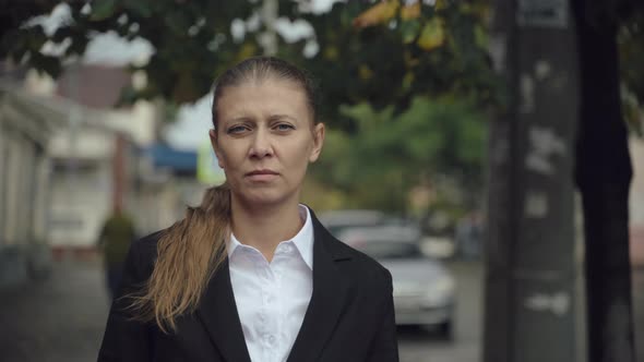 Business Woman In The City In A Black Suit And A Face Mask alt
