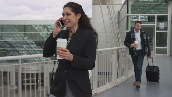 Businesswoman walking and talking at airport