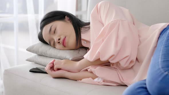 Close up Asian black hair woman lying down on sofa and sleeping at home alt