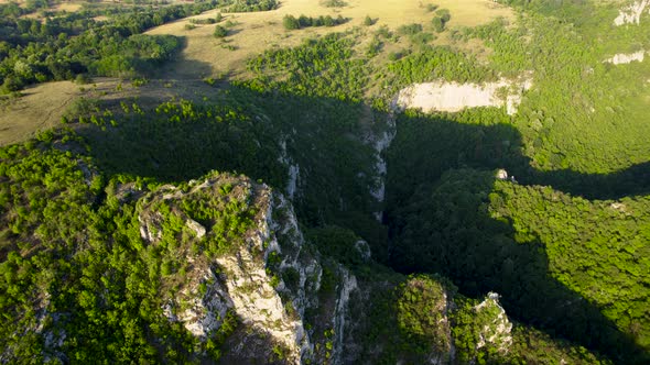 Aerial view of karst landscape, with valleys and cliffs, at sunset
