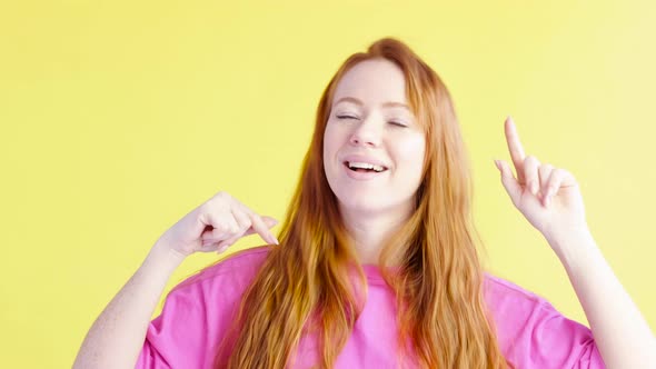 woman is dancing on an yellow background and twirling fingers near her head.