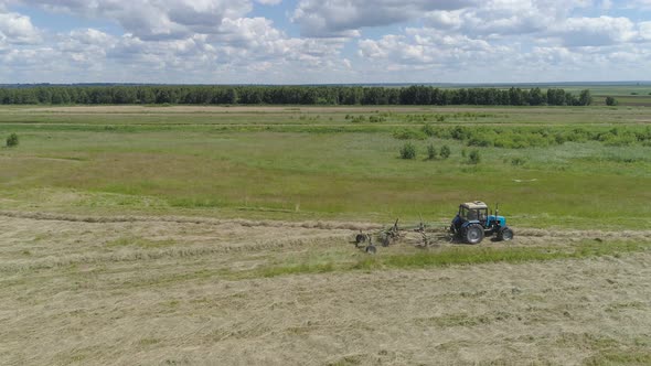 Tractor with Rake Tedders on the Farm Field alt