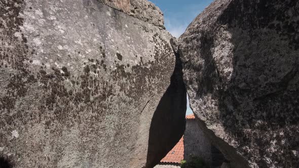 Two massive stones make a doorway on a cobblestone path leading to Monsanto Village. alt