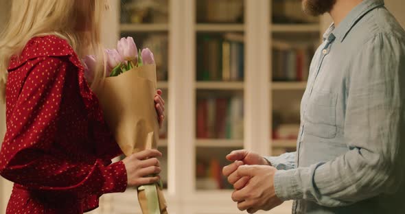 Man Giving a Woman a Bouquet of Flowers