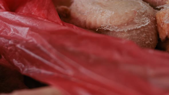 Closeup View of Hands in Gloves Packing Chicken Legs From a Box Into Individual Plastic Bags alt
