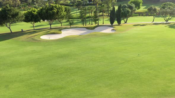 Aerial view of a golf court during a sunny day. alt