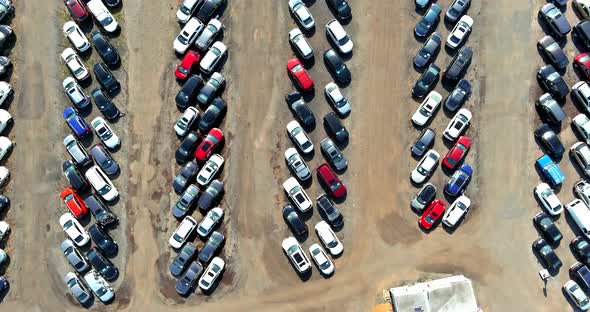 Top aerial view of auto auction many used car lot parked distributed in a parking. alt