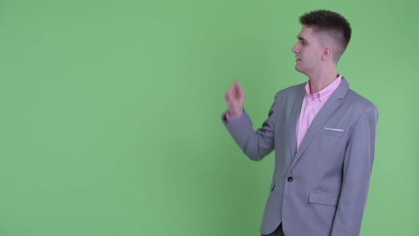 Happy Young Businessman Touching Something and Giving Thumbs Up