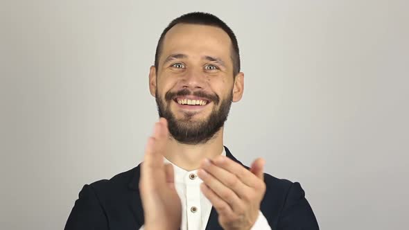 Handsome Young Businessman Smiling and Actively Clapping Hands Greeting New Customers