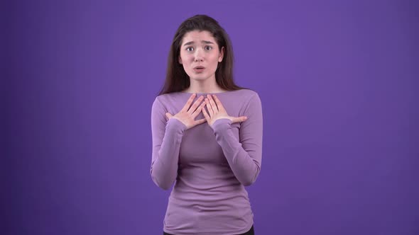 The Beautiful and Charismatic Young Woman Puts Her Hands on Her Chest and Speaks Until She Displays alt
