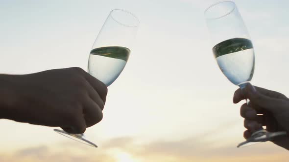 Man and Woman Clinking Wine Glasses Against Evening Sky, Romantic Date, Love