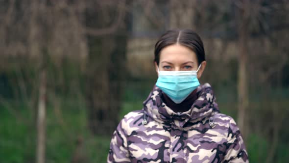 Young Woman Takes Off Medical Mask and Looks at Camera. Healthcare and Medical Concept. Pandemic