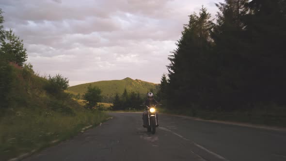 Man Riding Motorcycle on Windy Mountain Asphalt Road alt