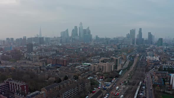 dolly back drone shot of Central London Skyline over overground railway lines alt