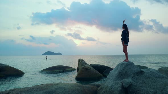 Cute Smiling Asian Girl Waving on a Rock at Sunset in Slow Motion Thailand