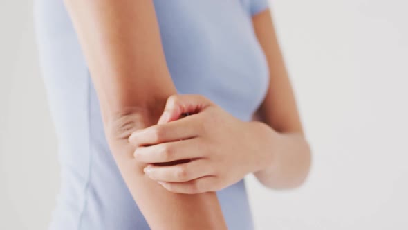 Video of biracial woman touching her arm on white background alt