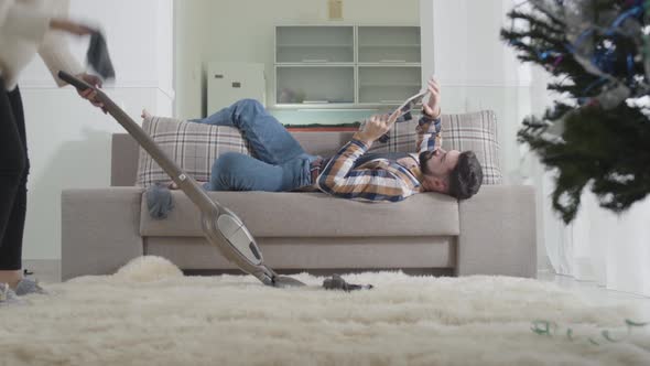 Young Caucasian Blond Woman Cleaning Up at Home, Finding Husband's Sock and Scolding Man. Lazy alt