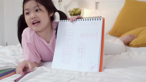 Asia japanese woman child kid relax rest fun happy draw cartoon in sketchbook. alt