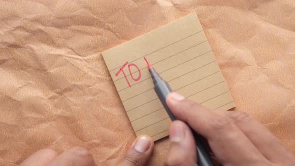 Writing a to Do List on a Sticky Note alt