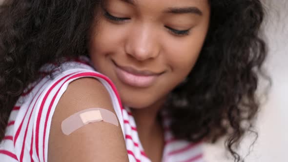 Vaccinated African American Woman Showing Arm with Medical Plaster Patch Plaster On Shoulder Black alt