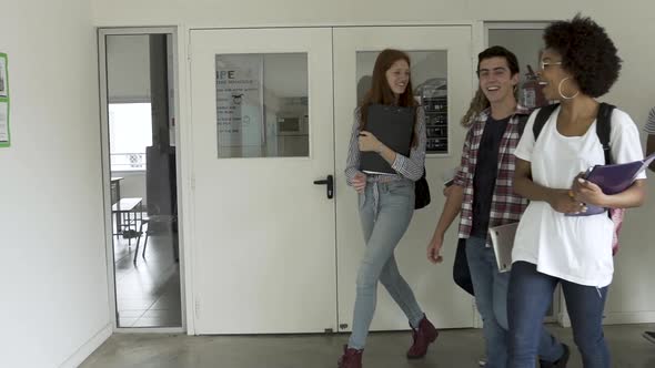 Students walking and cheering in college corridor