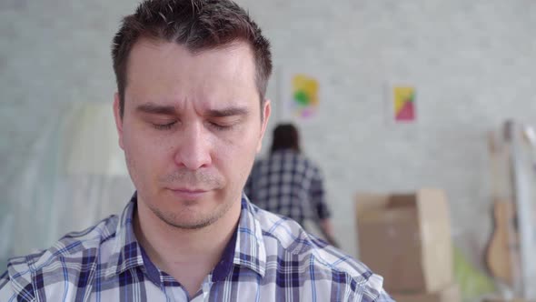 Unhappy Man's Face During the Divorce in the Background of the Box To Move alt
