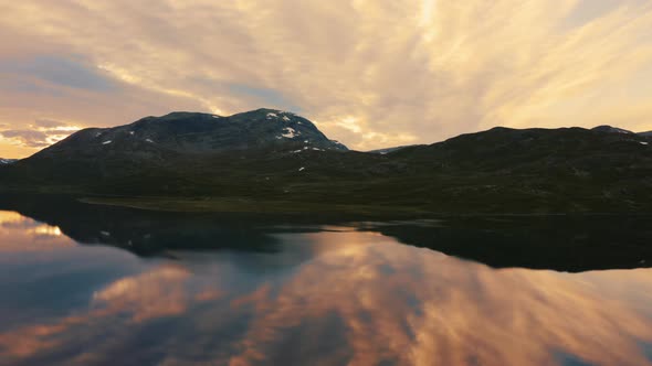 The beautiful sunset sky over the Norwegian mountains and lake Vavatnet - aerial alt