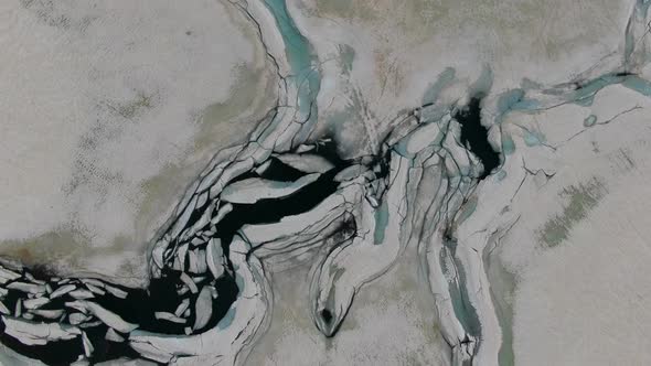 Drone shot of the chunks of ice on the mountain lake (Bachalpsee in Switzerland) alt