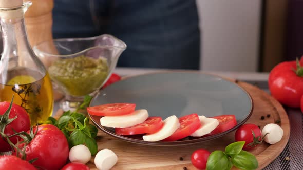 Making Caprese Salad  Putting Sliced Tomatoes and Mozzarella on a Plate alt
