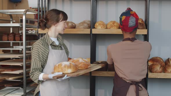 Multiethnic Women Smiling and Chatting during Workday in Bakery alt