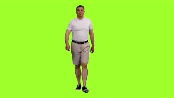 Adult Man in Shorts and White T-shirt Walks on Green Background ...