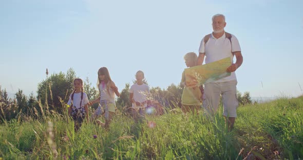 Young Tourists Walking in Meadow in Sunny Day alt